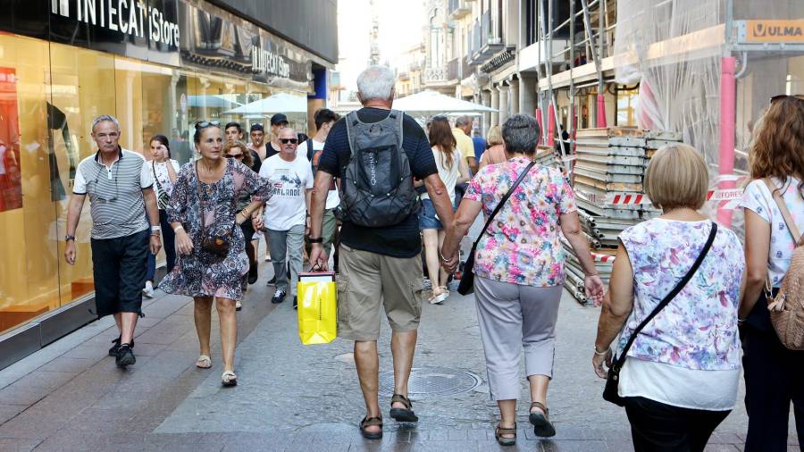 Turistas de compras, el pasado jueves por la tarde por el centro de Reus. Foto:Alba Mariné
