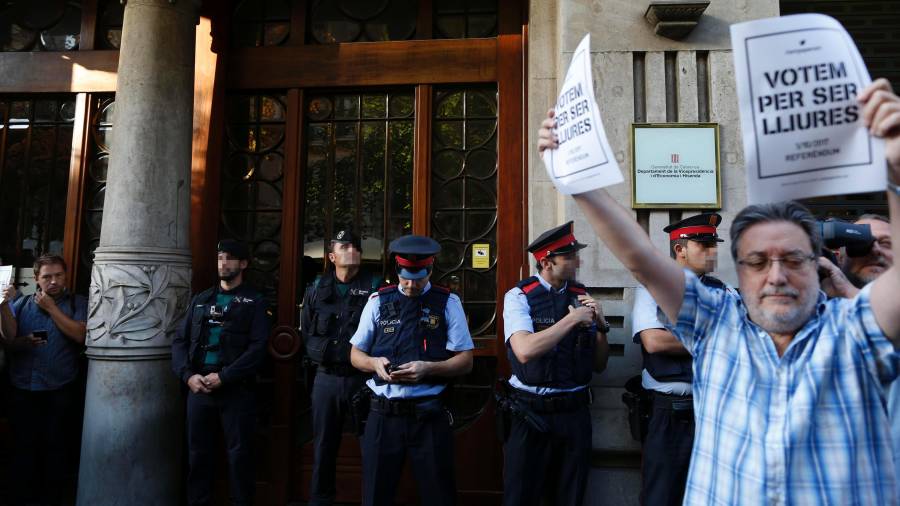 Agents de la Guàrdia Civil i dels Mossos d'Esquadra, a la porta de la conselleria d'Economia de la Generalitat