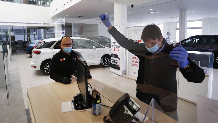 Las marcas preparan su vuelta. Operarios instalan una mampara en el concesionario de Citroën en el polígono de Les Gavarres. Foto: Pere Ferré