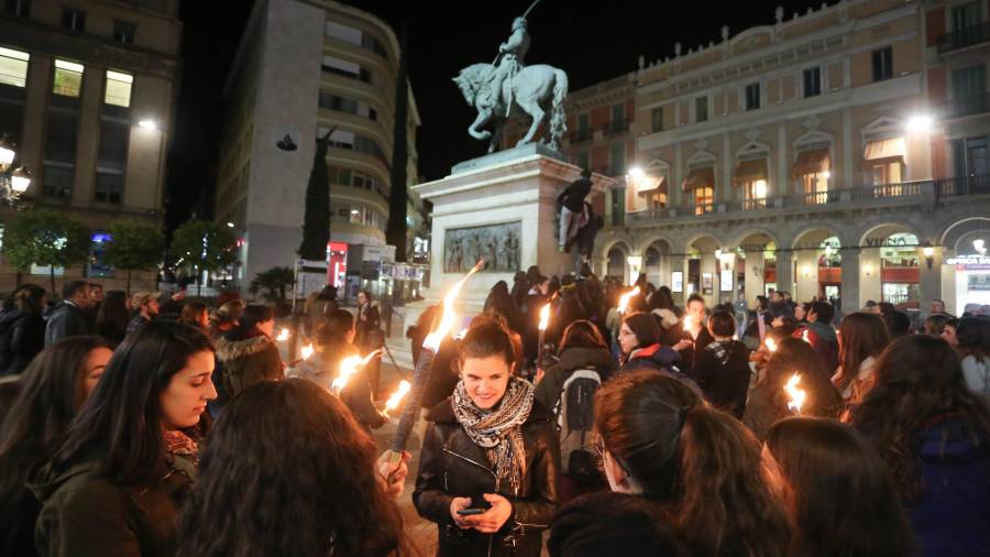 Un grupo de manifestantes colocando un delantal en la estatua del General Prim FOTO: Alba Mariné