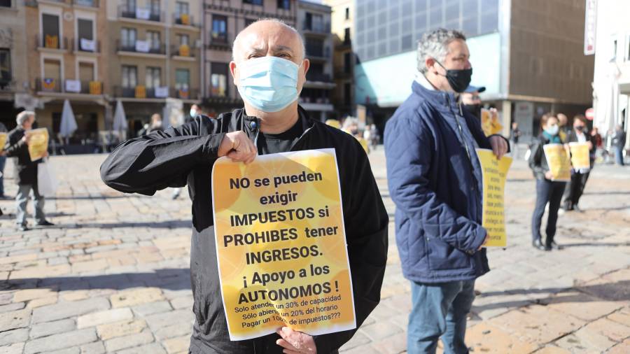 Un dels manifestants al Mercadal, ensenyant un cartell reivindicatiu. FOTO: ALBA MARINÉ