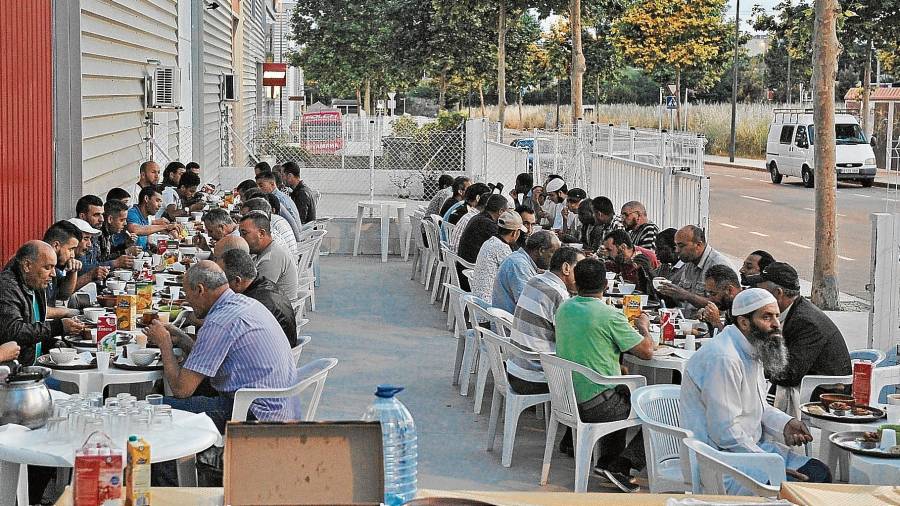 Unos 70 fieles, rompiendo el ayuno del Ramadán en el exterior de la mezquita de Reus, el pasado miércoles cuando se ponían el sol. Foto: Alfredo González