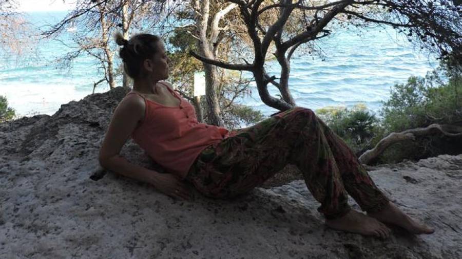 Natalia Rodríguez, descansando sobre una roca a la sombra de los pinos en el Bosc de la Marquesa, con el mar de fondo. FOTO: Cedida