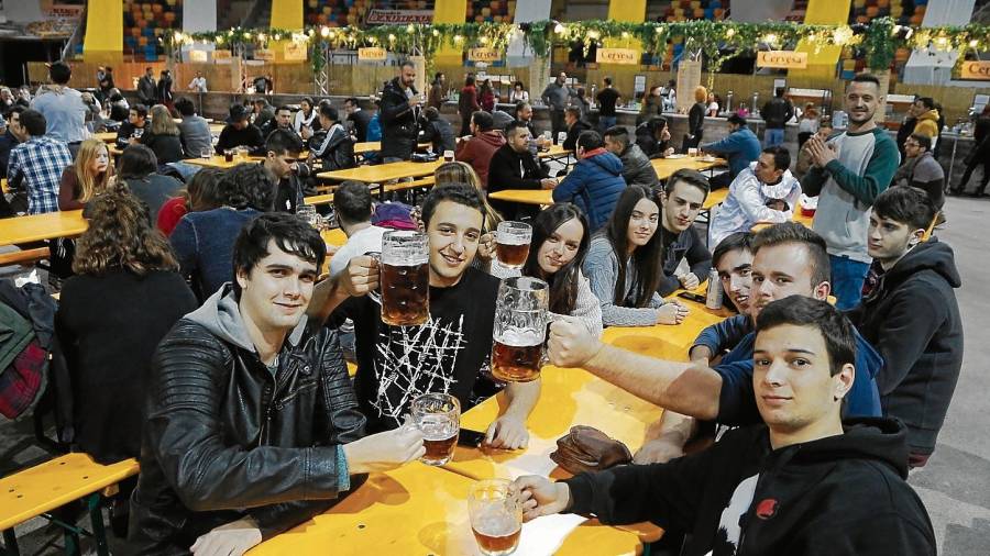 Un grupo de amigos se reúne en torno a una mesa en la feria de la cerveza de la TAP. FOTO: pere ferré