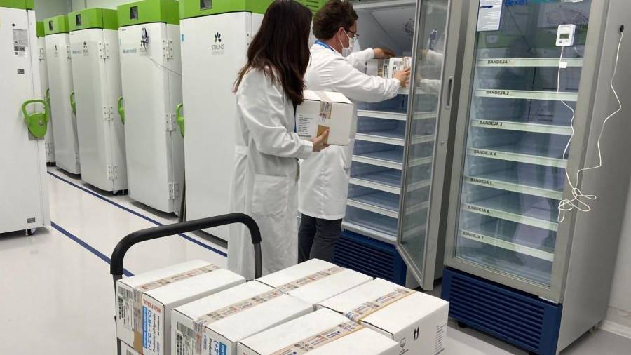 Imagen de dos técnicos de laboratorio guardando dosis de la vacuna de AstraZeneca. EFE