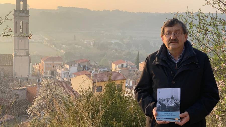 Josep Santesmases amb el seu llibre. De fons, el campanar de Vila-rodona, poble d’on és veí. FOTO: JÚLIA GIRIBETS