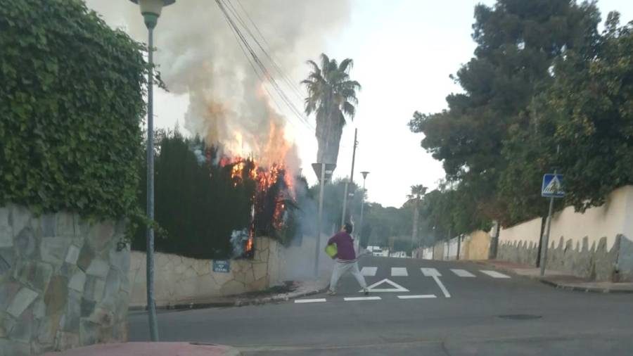 Un vecino se enfrenta a las llamas con cubos de agua.