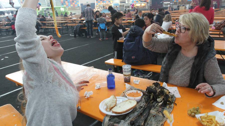 Dos personas degustan calçots en la feria de la Tarraco Arena Plaça. FOTO: Lluís Milián