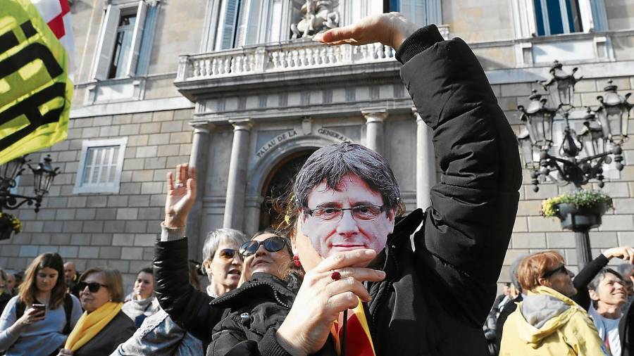 Imagen de uno de los manifestantes que ayer acudió con una máscara de Carles Puigdemont a la Plaça Sant Jaume. FOTO: efe