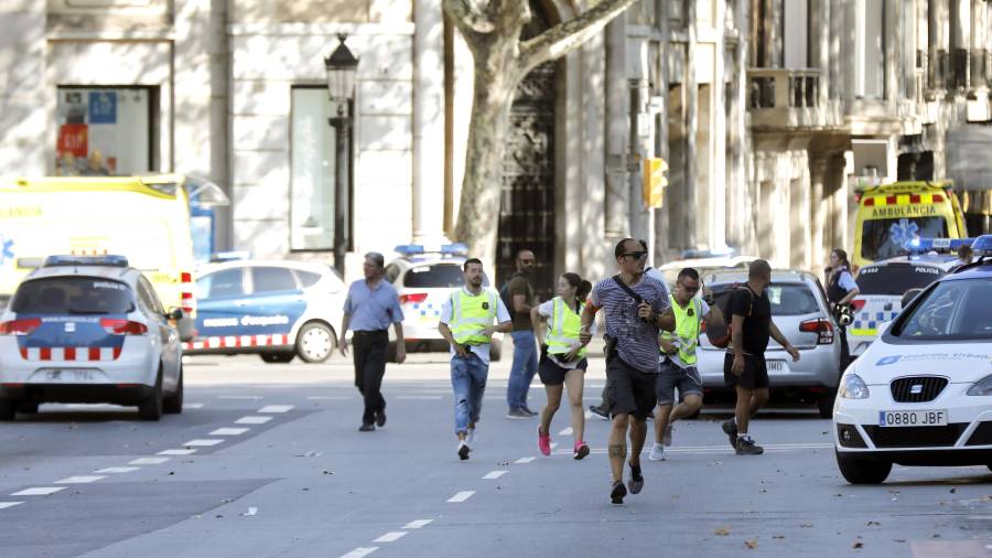 Efectivos policiales se despliegan en el centro de Barcelona, mientras algunos ciudadanos huyen del lugar de la tragedia, poco después del ataque. Foto: efe
