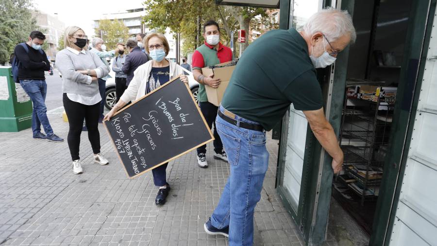 Julio Dueñas, y la familia y trabajadores del quiosco, ayer al mediodía, en el momento de cerrar definitivamente el negocio. FOTO: Pere Ferré