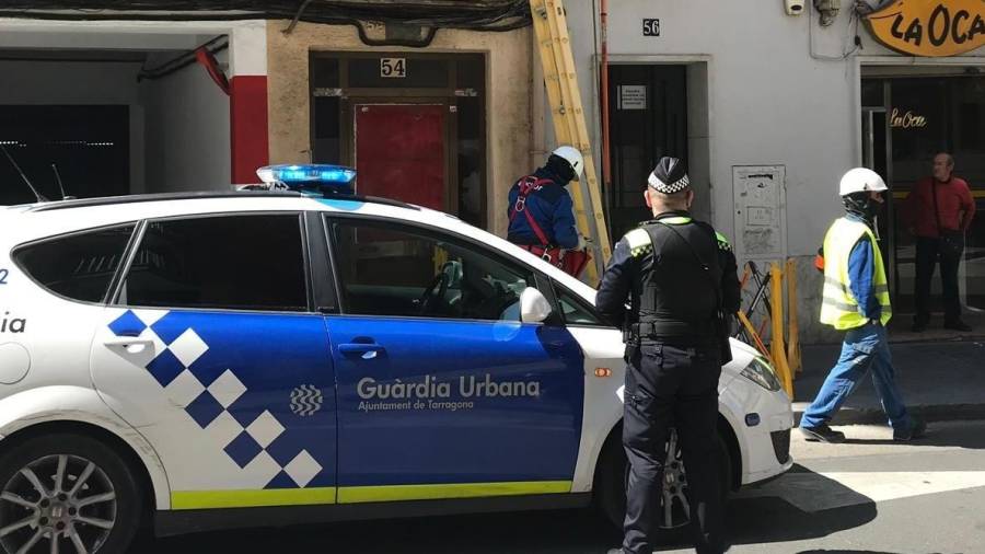 Un operario de Endesa, acompañado de agentes de la Guàrdia Urbana, cortó ayer el suministro eléctrico del bloque. FOTO: cedida
