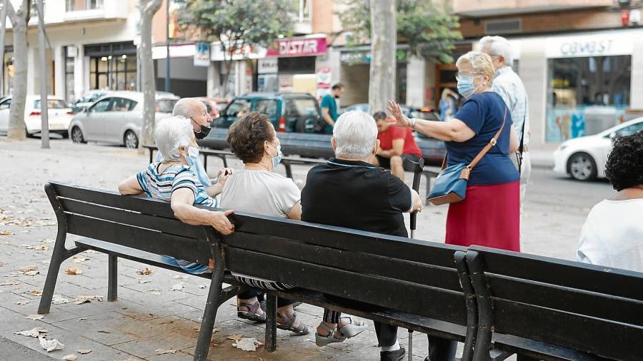 Varias personas mayores charlando en un banco del paseo Prim de Reus. Foto: A.M.