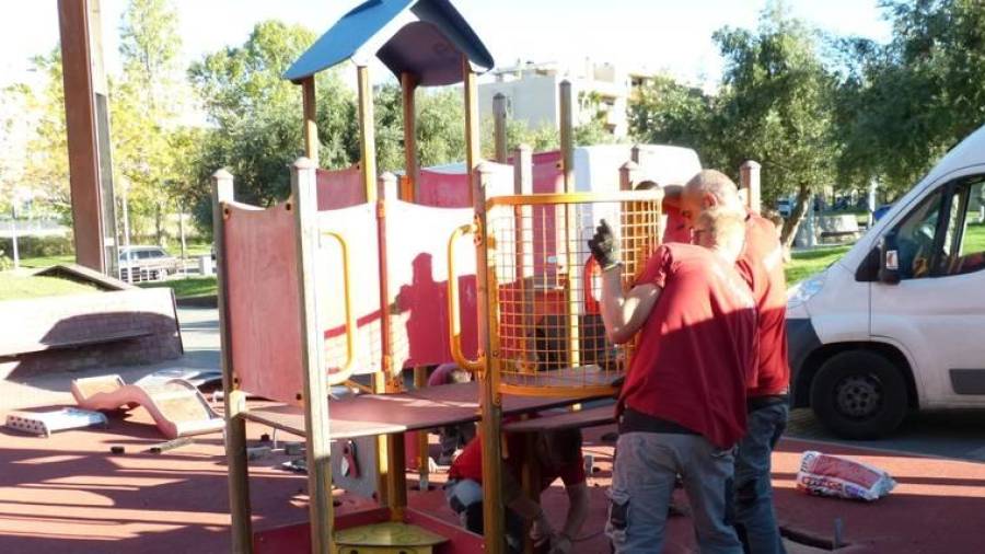 Operarios trabajando en la instalación de un parque infantil en la Plaça d’Andalusia.