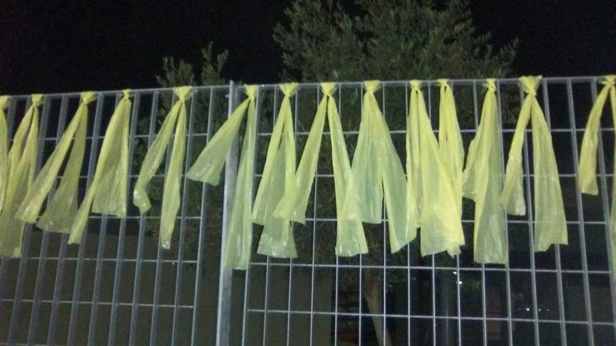 Pla mig de nombrosos llaços grocs penjats a la tanca de l'Institut Marta Mata de Salou. FOTO: ACN