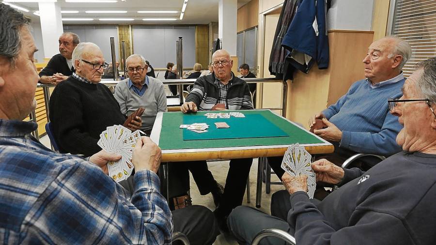Varios pensionistas conversan y juegan a las cartas en la cafetería del hogar de jubilado de Pere Martell, en Tarragona. Foto: Pere Ferré