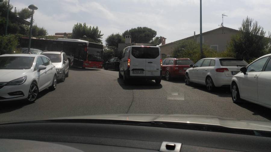 Una furgoneta tiene que dar marcha atrás para dejar pasar al autobús. Hay coches aparcados a ambos lados del Passeig de l’Esquirol. Foto: DT