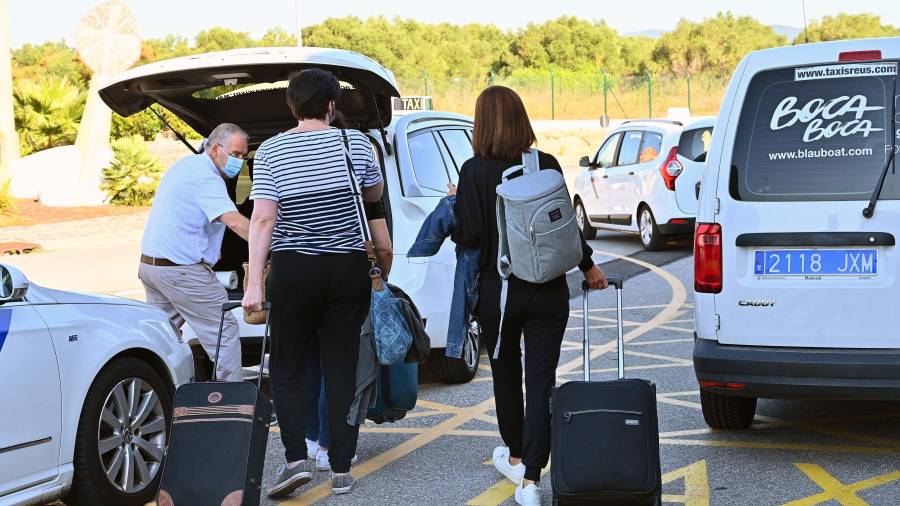 Pasajeros saliendo ayer por la mañana en el Aeropuerto de Reus y dirigiéndose a un taxi. FOTO: ALFREDO GONZÁLEZ