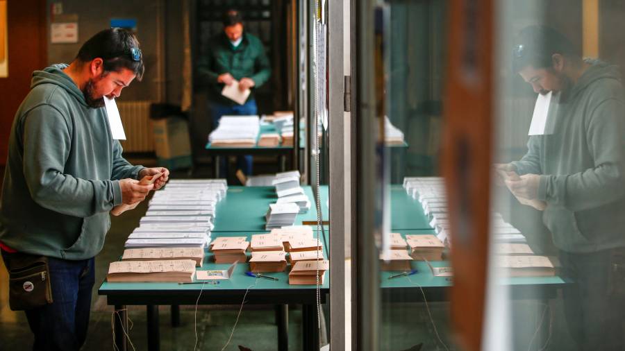 Ciudadanos buscan su papeleta de voto en un colegio de Barcelona. FOTO: EFE