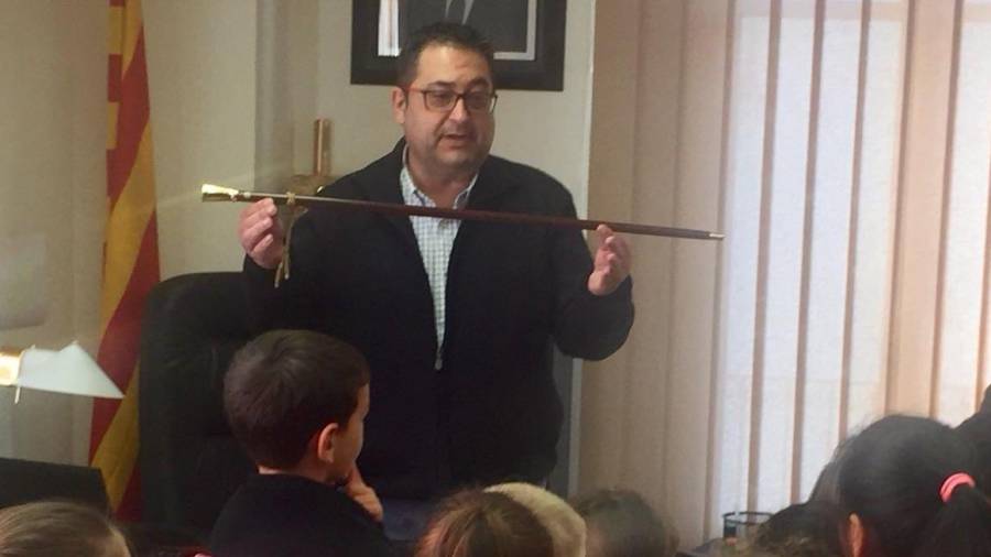 Joan Piñol ensenya la vara d'alcalde a escolars. La tornarà a tenir quatre anys més. FOTO: Aj. Móra d'Ebre