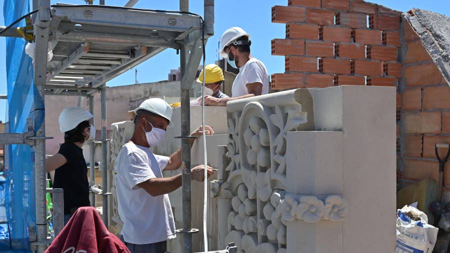 Los profesionales colocando las primeras piezas del frontispicio (hechas con piedra) en Casa Navàs. FOTO: ALFREDO GONZÁLEZ