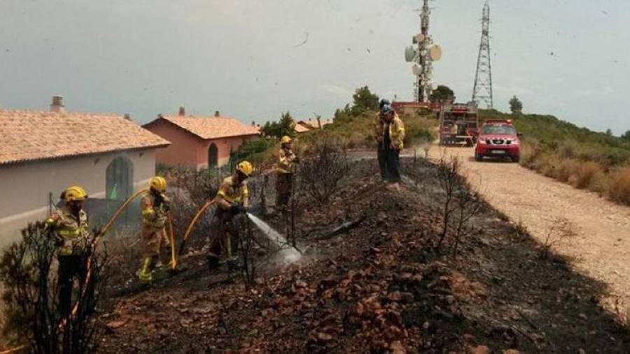 Los bomberos remojan la zona de Segur zona tras sofocar las llamas.
