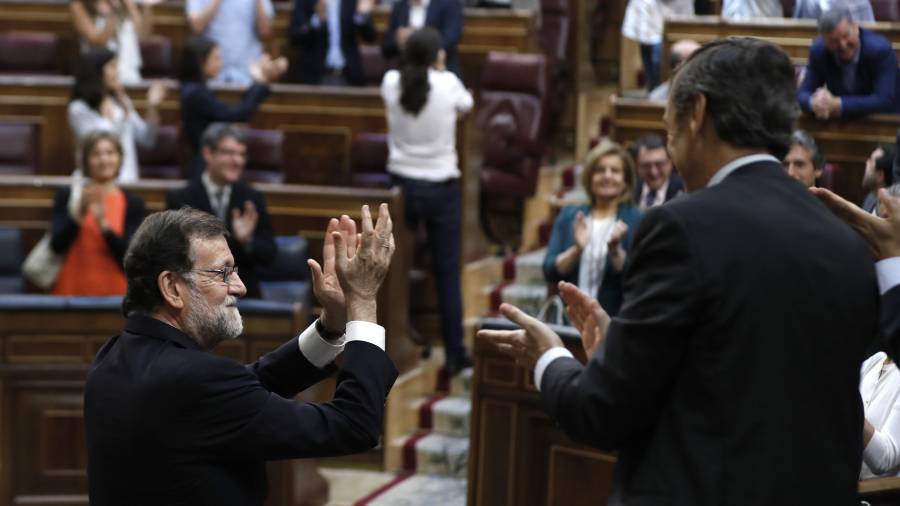 El presidente del Gobierno, Mariano Rajoy (i), junto al portavoz parlamentario del PP, Rafael Hernando, aplaude con la bancada popular tras la votación. Foto: emilio naranjo/efe