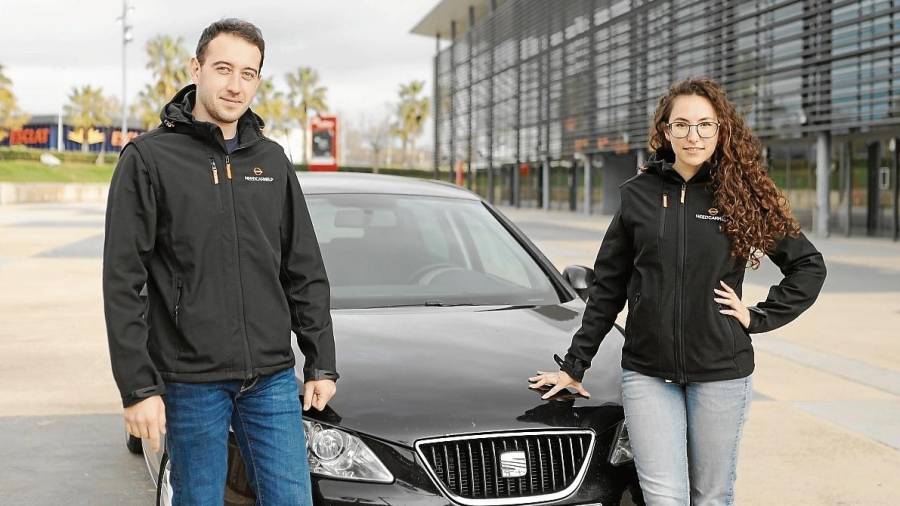 Marta Sol y Sergey Savchak, junto al coche que les llevó hasta la idea de crear Needcarhelp. FOTO: Alba Mariné