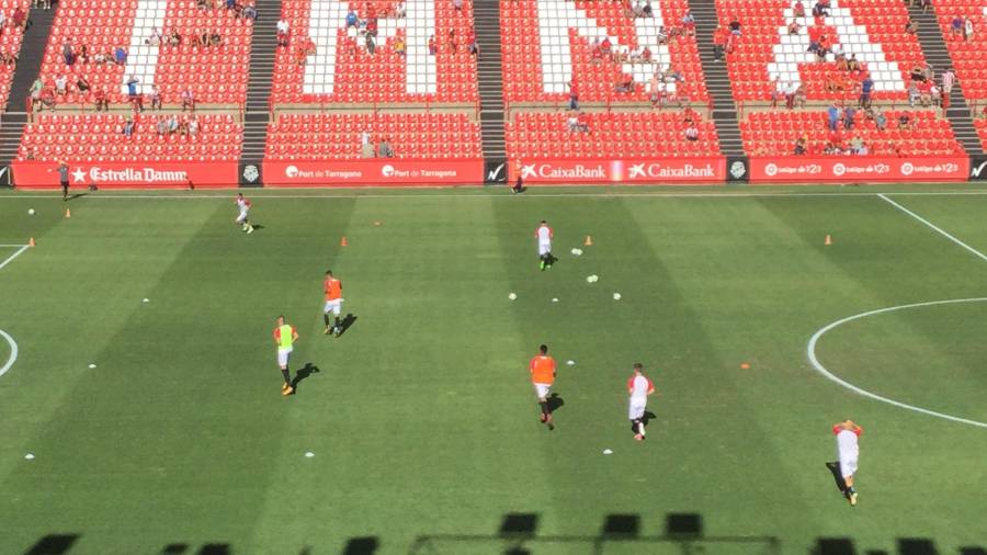 Los jugadores grana calientan sobre el terreno de juego del Nou Estadi.