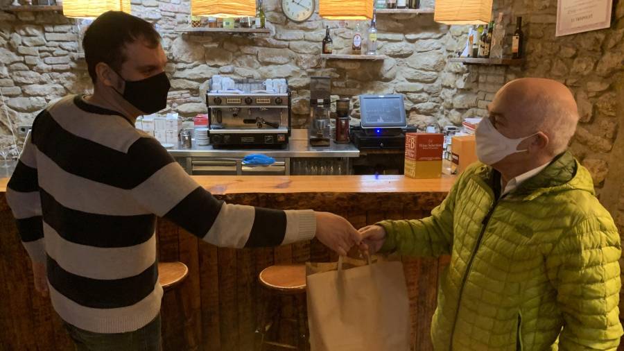 Octavi Roca, gerent i propietari del Trispolet de Valls, a l’esquerra de la imatge, fent entrega d’una comanda de menjar per emportar que han fet al seu restaurant. FOTO: J.G.