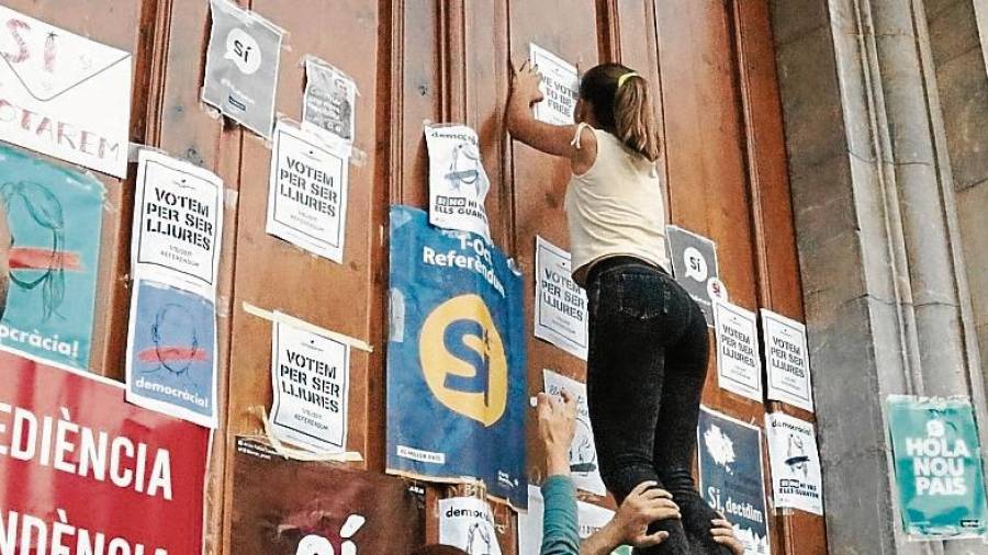 Activistes pengen cartells de l’1-O i a favor del ‘sí’ a la porta de l’Ajuntament de Tarragona, en una imatge de setembre. FOTO: ACN