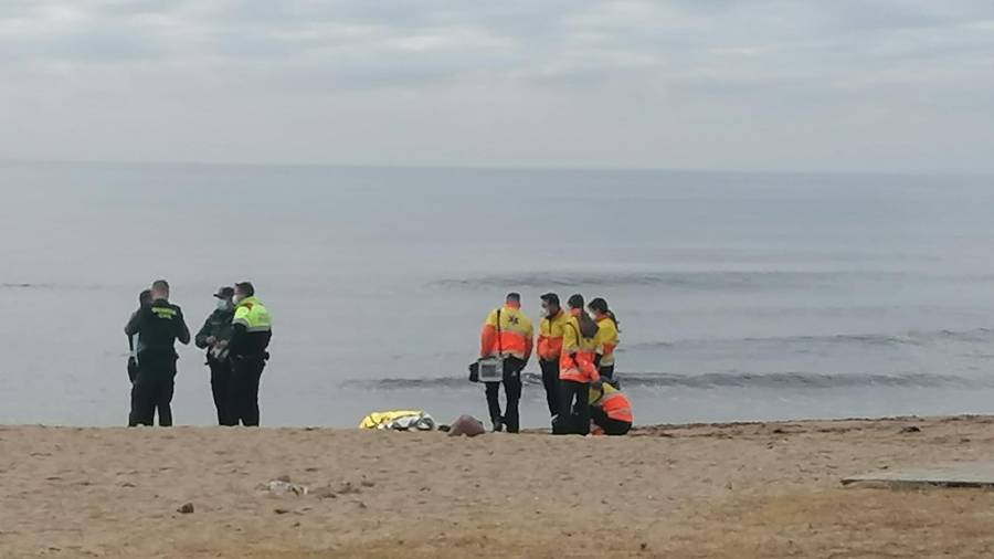 Personal del SEM y agentes policiales junto al cuerpo, en la playa. FOTO: DT