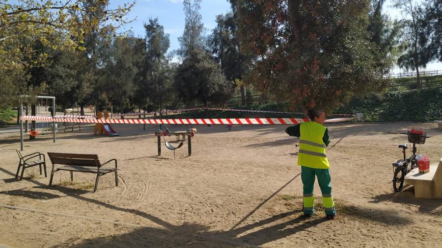 Una operaria cerrando una zona de juego infantil en Tarragona. Foto: J. RAM