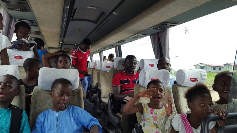 Un grupo de escolares de Guinea yendo a bordo de un autobús Hife.