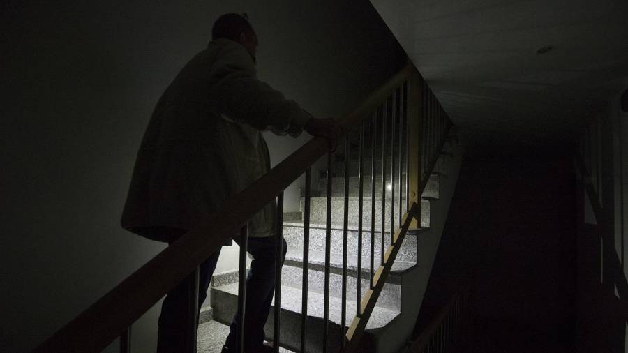 Els veïns es veuen obligats a pujar les escales a fosques, només amb la llum del seu telèfon mòbil. FOTO: Joan Revillas