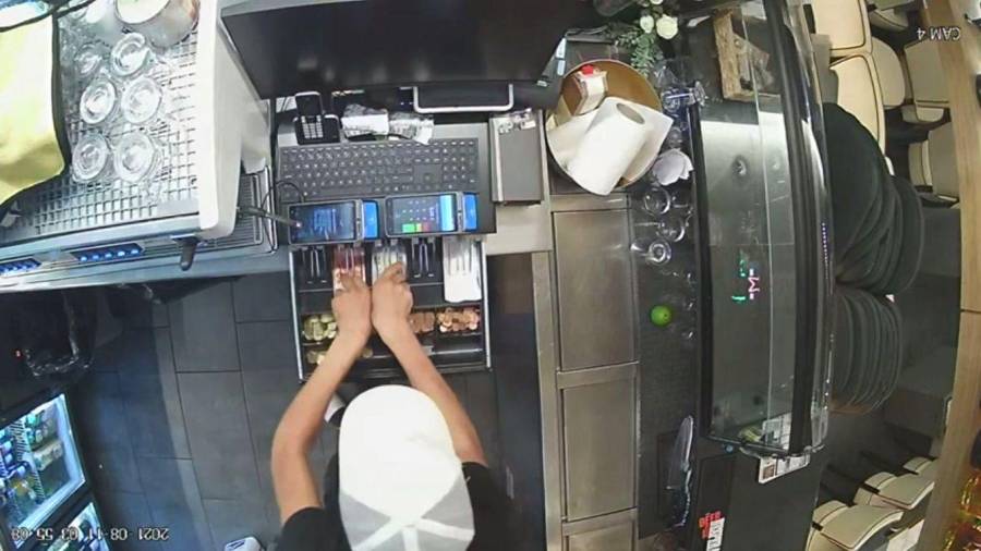 Uno de los ladrones cogiendo el dinero del restaurante, captado por una cámara de seguridad.