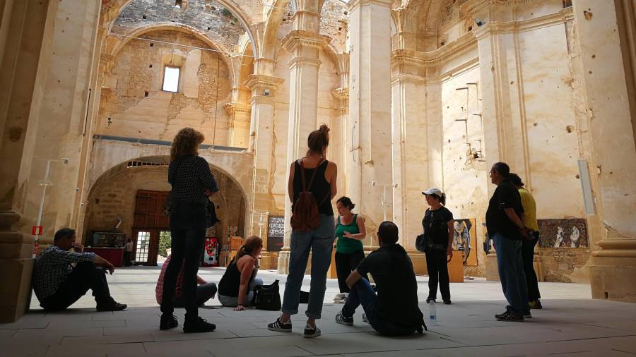 Un grupo de turistas durante una visita a la iglesia del pueblo viejo de Corbera d’Ebre, dentro de una ruta de Terra Enllà. FOTO: a.caralt