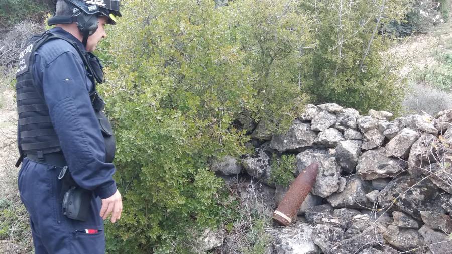 El sargento del TEDAX observa el proyectil de artillería hallado en Gandesa antes de proceder a su explosión. FOTO: Àngel Juanpere