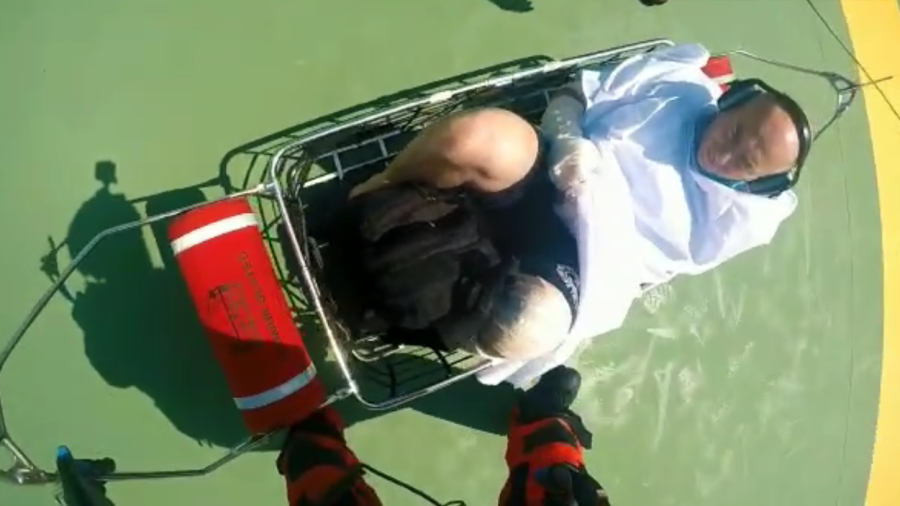 Momento en que el herido era llevado en una cesta desde el buque hasta el helicóptero. Foto: Salvamento Marítimo