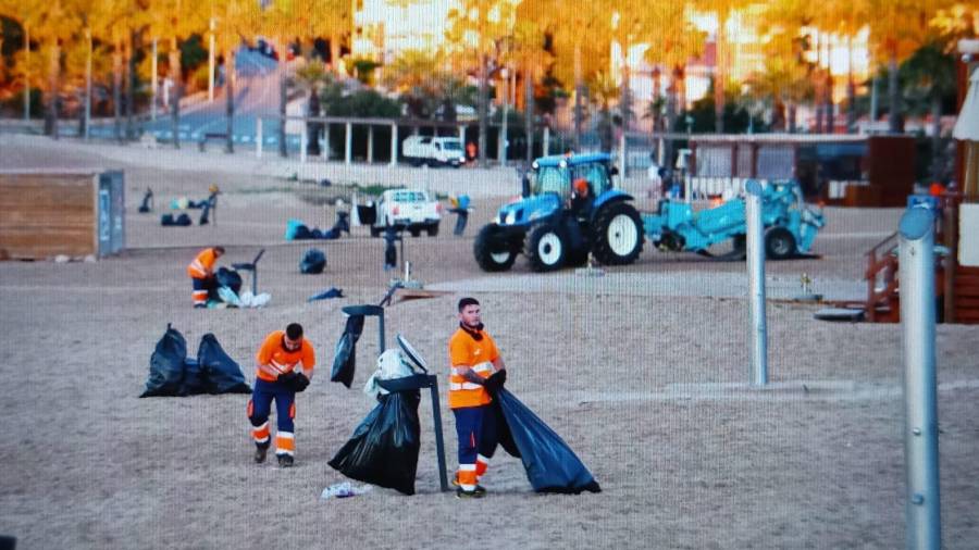 Operarios limpiando la arena antes de las siete de la mañana en l'Arrabassada. Foto: Pere Ferré