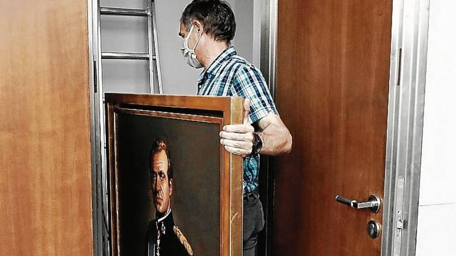 Un empleado del Parlamento navarro guarda en un almacen el retra-to de Juan Carlos I después de retirarlo de la «sala de gobierno». efe