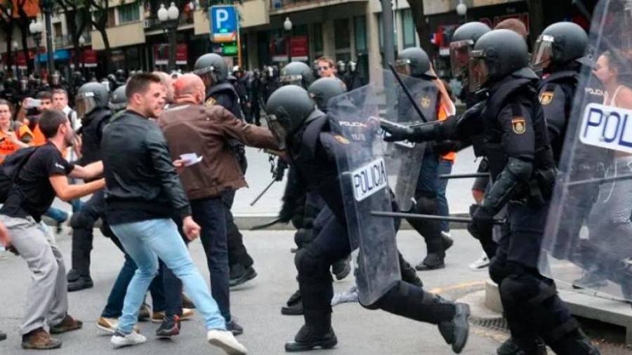 Agentes de la policía nacional intentan retirar a los concentrados en el instituto IES Tarragona. Foto: DT