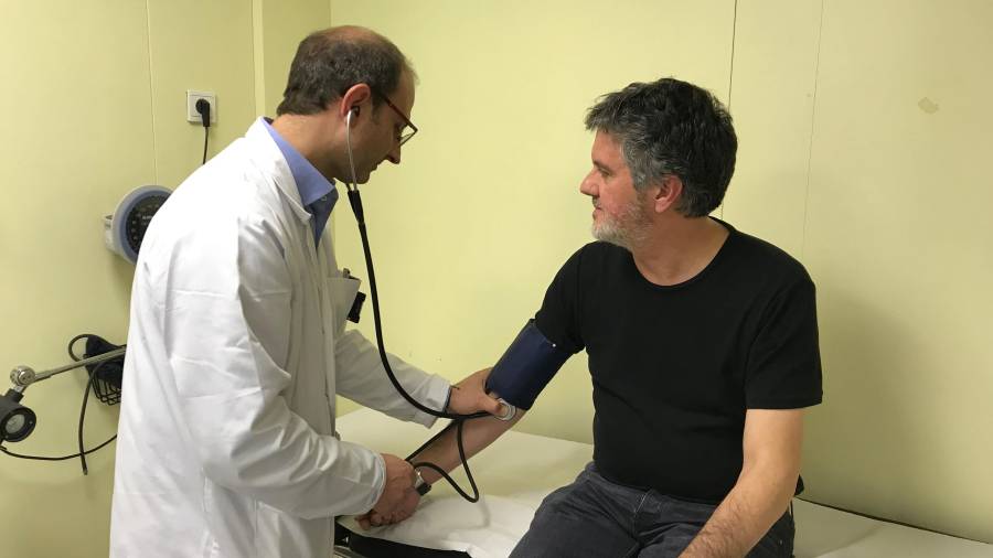 El doctor Magrinyà prenent la pressió a un pacient a la seva consulta de Valls. FOTO: ALBA TUDÓ
