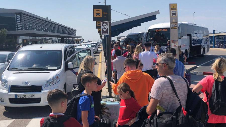 Imagen de las colas de viajeros esperando para coger un autobús en el Aeropuerto de Reus. Alfredo González