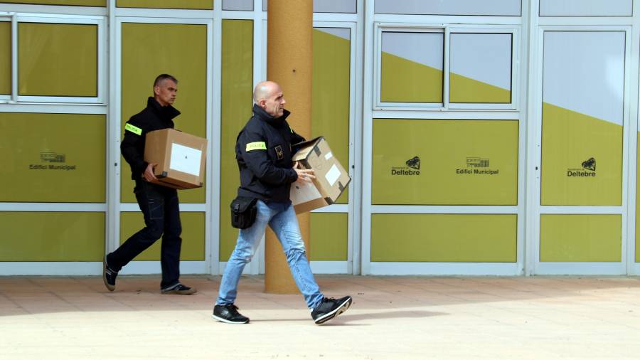 Dos agentes de los Mossos d'Esquadra con cajas de documentos saliendo del Ayuntamiento de Deltebre. FOTO: ACN