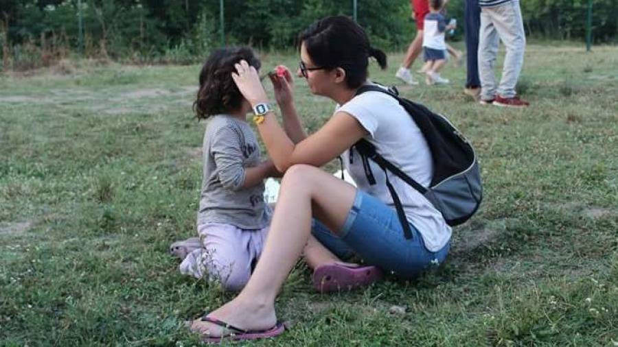 La cooperant canareva Anna Casabó ficant una flor a una xiqueta en un dels campaments a Sèrbia. Foto: cedida