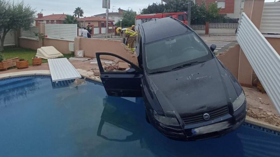 El coche ha derribado el muro y casi cae a la piscina.