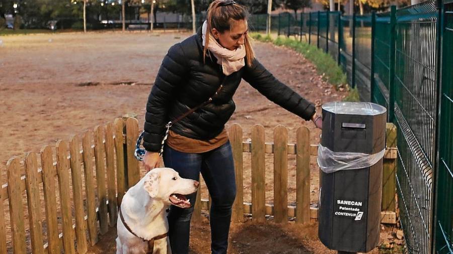 La propietaria de un perro utilizando una de las papeleras habilitadas en la ciudad. FOTO: alba mariné