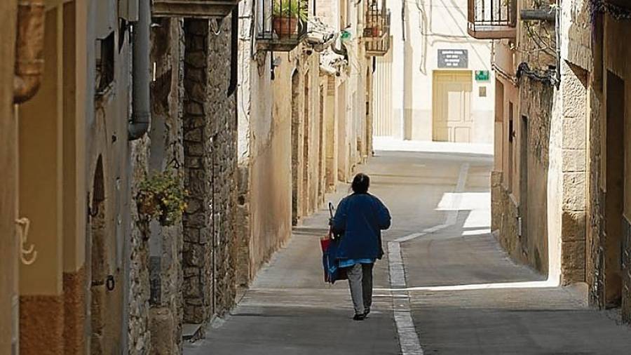 Una mujer camina por una calle de Caseres, un municipio que perderá dos concejales. FOTO: Joan Revillas