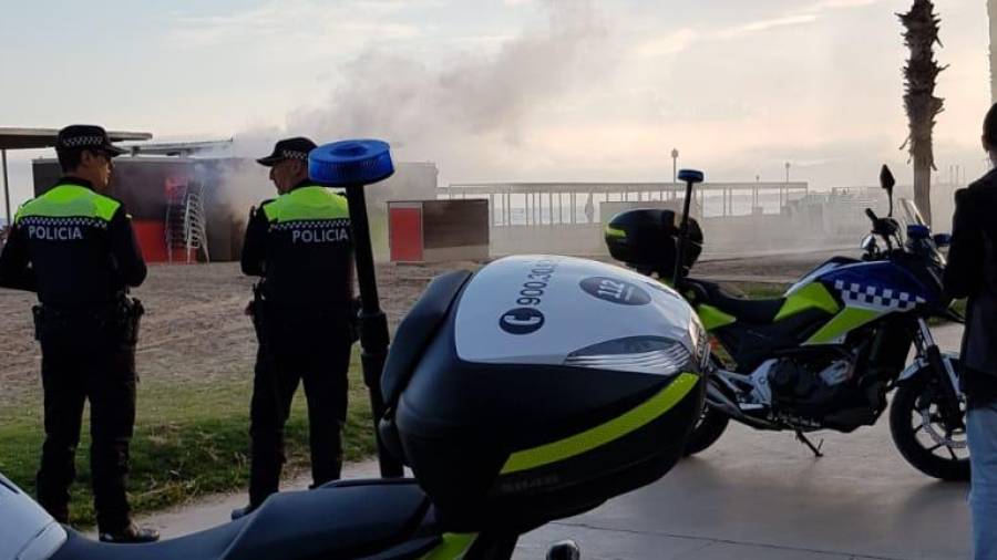 Dos agentes observan como se quema el chiringuito en Salou. FOTO: Miguel Ángel